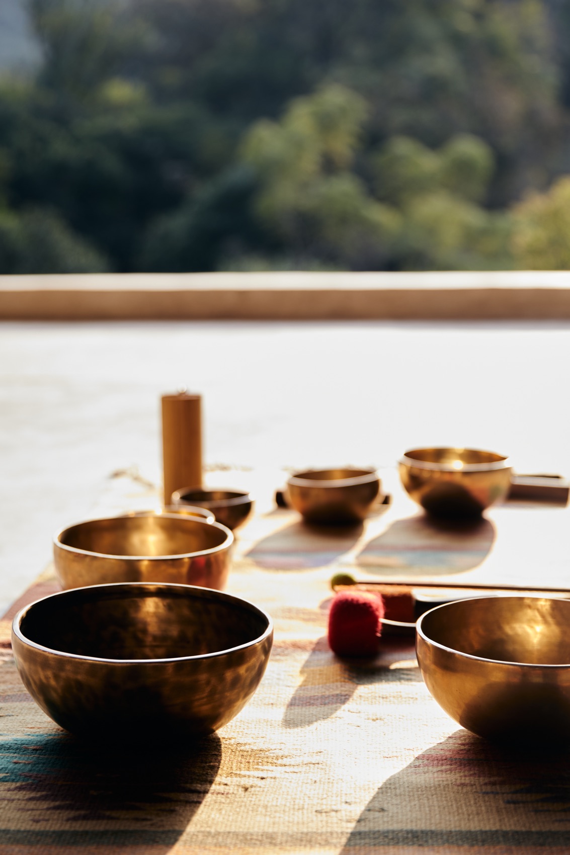 Tibetan singing bowls arranged on a wooden table in soft window light