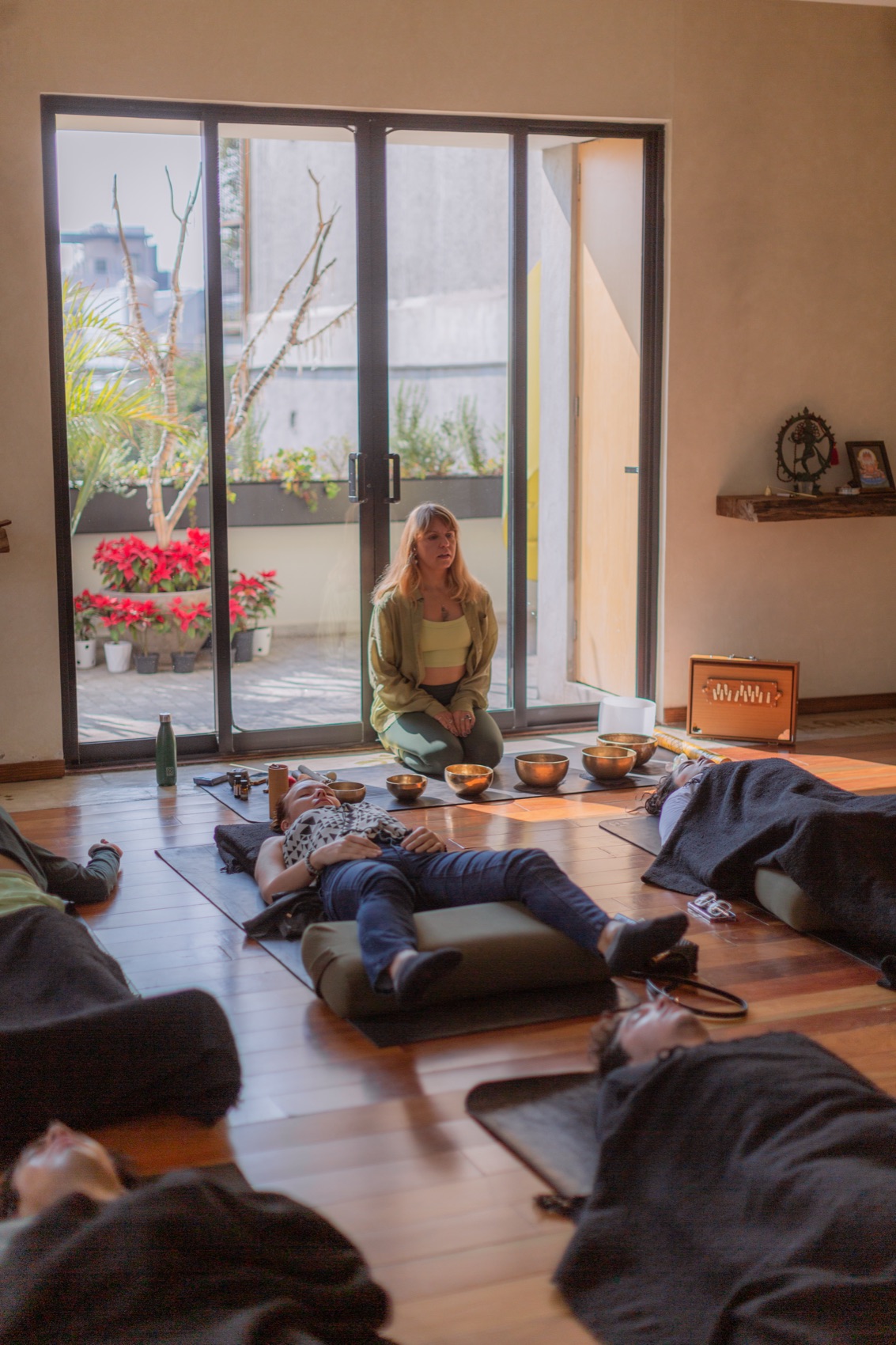 A group sound bath in a Mexico City studio with participants resting on mats